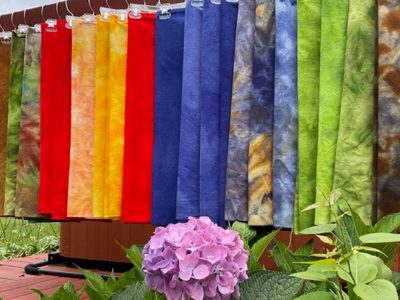 Periwinkle Laine Rug Hooking Supplies and Services - product samples hanging on a long rod