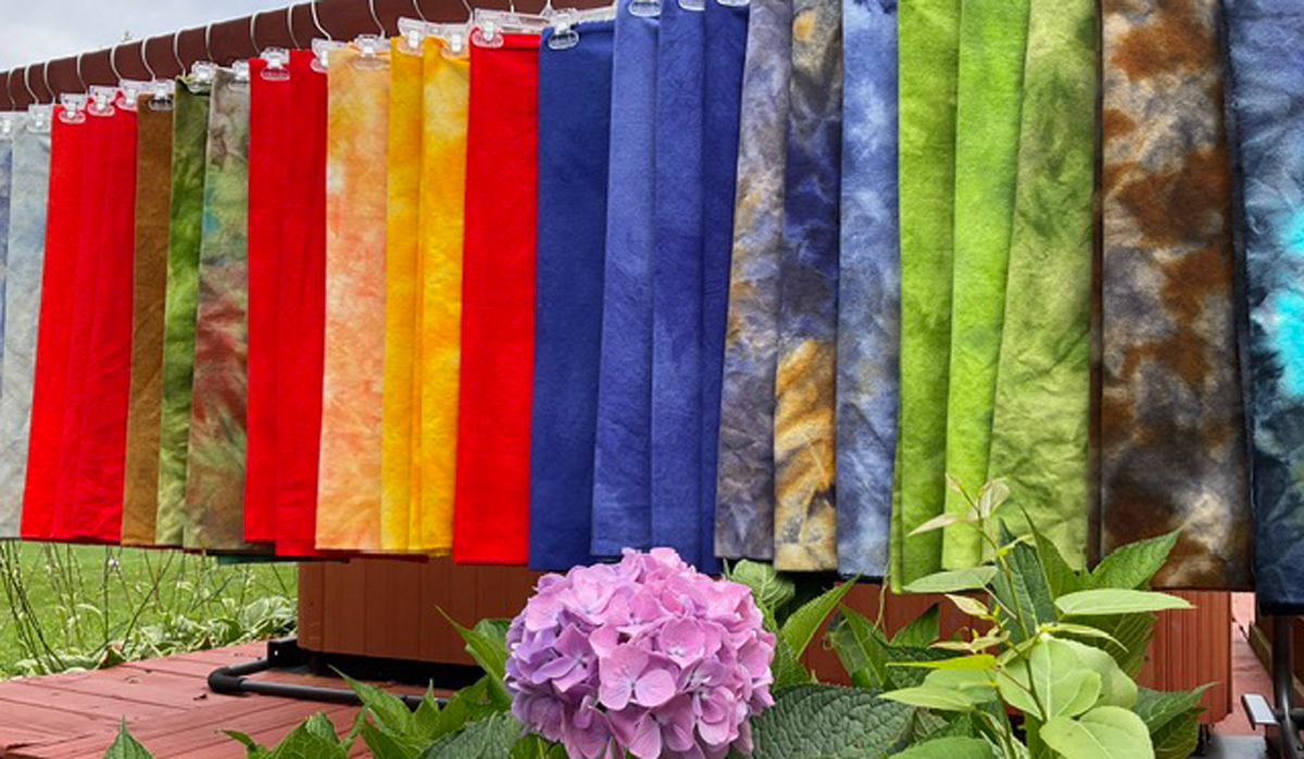 Periwinkle Laine Rug Hooking Supplies and Services - product samples hanging on a long rod